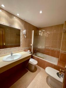 HOTEL LA FONDA DE DON GONZALO في ثينيس دي لا فيغا: حمام مع حوض ومرحاض وحوض استحمام