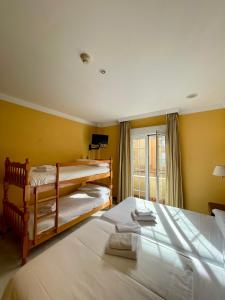 HOTEL LA FONDA DE DON GONZALO في ثينيس دي لا فيغا: سريرين في غرفة بجدران صفراء