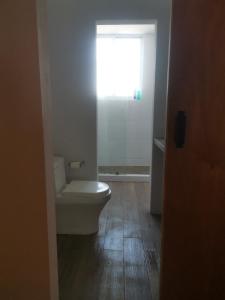 ein Badezimmer mit Toilette und Fenster in der Unterkunft Torre Mar Frente al Malecón Departamento 3 in Mazatlán