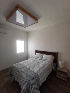 ein Schlafzimmer mit einem großen Bett mit Fenster in der Unterkunft Torre Mar Frente al Malecón Departamento 3 in Mazatlán