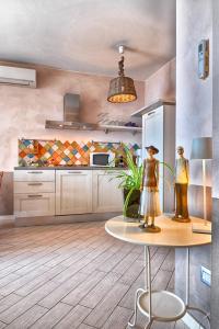 una cucina con tavolo e due statue sopra di BnB Borgo le Vigne - L'Uva rara Only Adults a Tignale