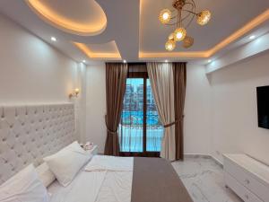 - une chambre avec un lit blanc et une fenêtre dans l'établissement sharm luxury apartment in sharm hills, à Charm el-Cheikh