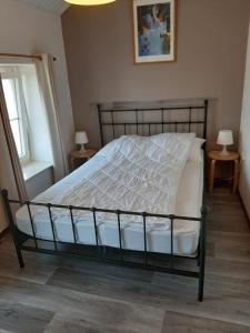 een bed in een slaapkamer met 2 lampen en een raam bij Vroeleneind in Noorbeek