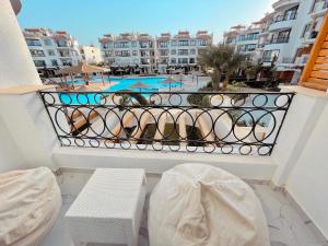 un balcon avec un banc et une piscine dans l'établissement sharm luxury apartment in sharm hills, à Charm el-Cheikh