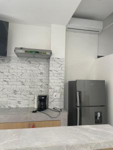 a kitchen with a refrigerator and a counter top at Hotel Sabana Inn in San José