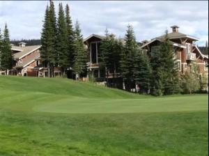 a golf course with a house in the background at Cozy 2 Bedroom 2 Bathroom Ski in Ski out Townhouse in Sun Peaks