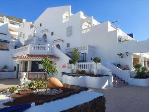 a white building with some plants in front of it at Pool & View Christianos in Los Cristianos