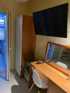 einen Schreibtisch mit einem Computermonitor darüber in der Unterkunft Apartments Teatina in Brodarica