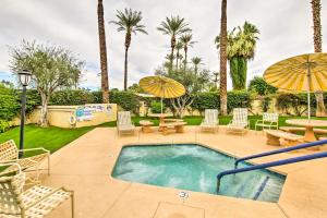 een zwembad met stoelen, tafels en parasols bij Modern Palm Springs Condo with Pool, Hot Tub Access! in Palm Springs