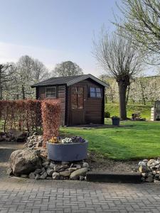 eine kleine Hütte mit einem Blumentopf davor in der Unterkunft Vroeleneind in Noorbeek