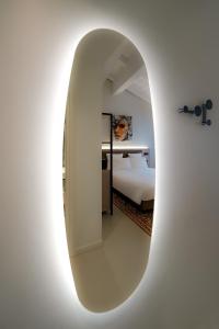 biały pokój z łóżkiem i lustrem w obiekcie Bergamo INN 21 w Bergamo