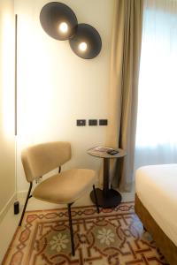 貝加莫的住宿－Bergamo INN 21，一间卧室配有一张床、一把椅子和一张桌子