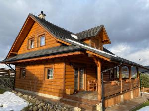 a log cabin with a porch and a roof at Nowica 71 Relax Dom Świerkowy in Nowica