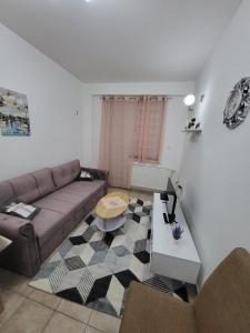 uma sala de estar com um sofá e uma mesa em Lavander em Banja Luka