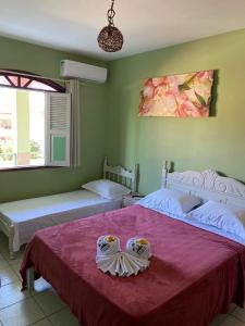 1 dormitorio con 2 camas y colcha roja en Pousada Brisa do Sul, en Santa Cruz Cabrália