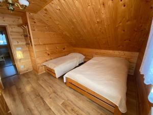 a room with two beds in a wooden cabin at Nowica 71 Relax Dom Świerkowy in Nowica