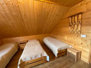 Habitación con 2 camas en una cabaña de madera en Nowica 71 Relax Dom Świerkowy en Nowica