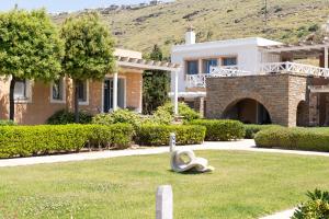 a house with a statue in the grass at Porto Kea Suites by Sandglass in Korissia