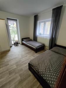 a bedroom with two beds and a wooden floor at Apartmány Na Cestě in Desná
