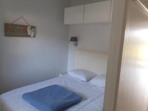 - une petite chambre avec un lit doté d'une couverture bleue dans l'établissement Appartement forever, à Les Sables-dʼOlonne