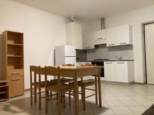 a kitchen with a wooden table and chairs in it at ADIGE MUSE HOME in Trento