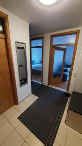 Habitación con 2 espejos y alfombra negra en MED MAN Apartmani, en Slavonski Brod