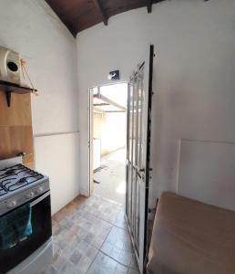 uma cozinha com um fogão e uma porta aberta em Alquiler Galo em Mar del Plata