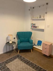 un salon avec une chaise bleue et une table dans l'établissement Comfy and welcoming 2 bedroom Annex., à Padstow