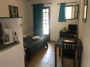 Camera piccola con letto e tavolo con macchinetta del caffè. di Le Clos des Arbousiers a Linguizzetta