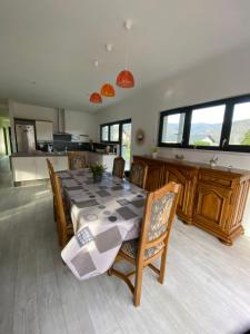 uma sala de jantar com mesa e cadeiras e uma cozinha em Chez Nono em Mitzach