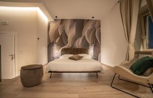 a bedroom with a bed and a chair at LA BANCHINA LUXURY SUITES in Trani