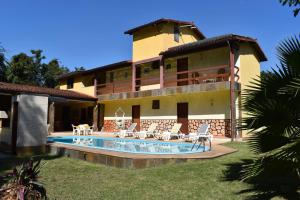 una casa con piscina frente a ella en Pousada Santa Anna, en Itaipuaçu