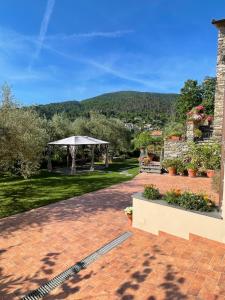 un patio con cenador y montañas de fondo en IL CASALE DEL MAGRA en Ameglia