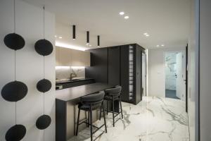 kuchnia z czarno-białymi ścianami i stołkami w obiekcie Luxury Apartment Contesa w Rovinj