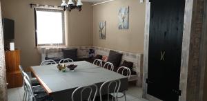 a dining room with a table and chairs and a couch at Forest gate Vendégház in Mátraszentimre