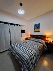 1 dormitorio con 1 cama grande con manta a rayas en BA Downtown Callao en Buenos Aires