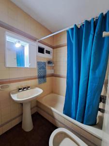 baño con lavabo y cortina de ducha azul en BA Downtown Callao en Buenos Aires