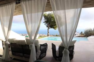 una camera con tende e vista sulla piscina di Amazing Villa in Benalmadena a Benalmádena