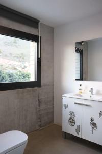 bagno con servizi igienici, lavandino e finestra di Amazing Villa in Benalmadena a Benalmádena