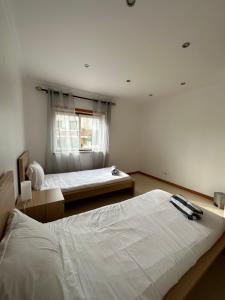 um quarto com 2 camas e uma janela em Ocean Guesthouse Baleal em Ferrel
