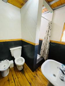 a bathroom with a toilet and a sink at Cabaña El Cristo in La Cumbre