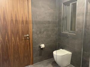a bathroom with a toilet and a wooden door at Luxurious sunlit maisonette with large terrace! in Marsaskala