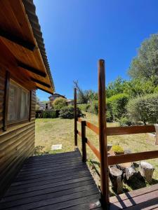 a wooden walkway leading to a cabin with a fence at Cabaña El Cristo in La Cumbre