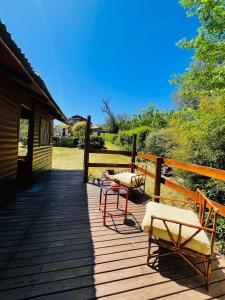 a deck with chairs and tables on a cabin at Cabaña El Cristo in La Cumbre