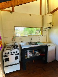 a small kitchen with a stove and a sink at Cabaña El Cristo in La Cumbre