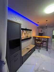 a living room with a large tv and a table at Cezar Apartments in Podgorica