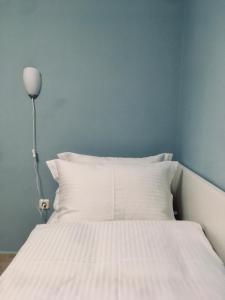 a bed with white sheets and a lamp in a room at REM One Bedroom Apartment in Thessaloniki