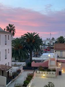 a sunset over a city with palm trees and buildings at Cap d’Agde Centre port avec parking privé et belle vue port et mer in Cap d'Agde