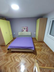 ein Schlafzimmer mit einem lila Bett und gelben Schränken in der Unterkunft Z A M A K in Niška Banja