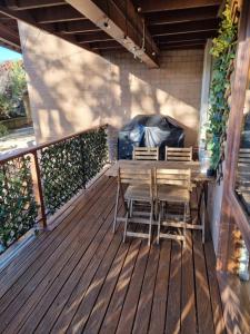 una terrazza in legno con tavolo e sedie. di *The Hideaway* Lake Views/Bike Storage/Smart Home/Free WiFi a Jindabyne